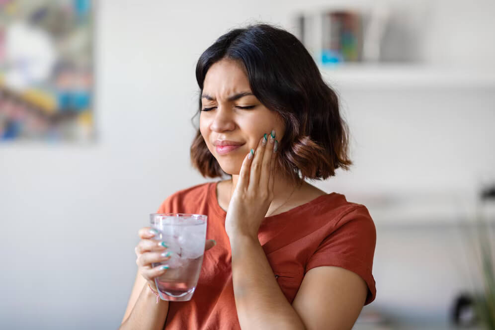 a woman experiencing tooth sensitivity to cold